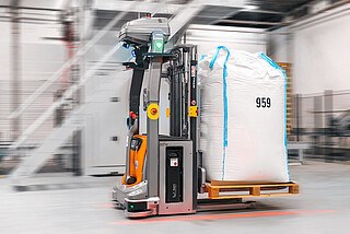 Zautomatyzowany wózek podnośnikowy STILL EXV w systemie iGo easy podczas przewozu ładunku w DP Supply.