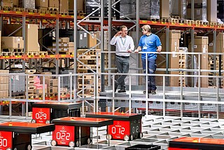 Łączące przenośniki, system AutoStore i tradycyjne wózki widłowe wdrożenie w magazynie części małych Siemens.
