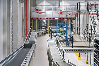Łączące przenośniki, system AutoStore i tradycyjne wózki widłowe wdrożenie w magazynie części małych Siemens.